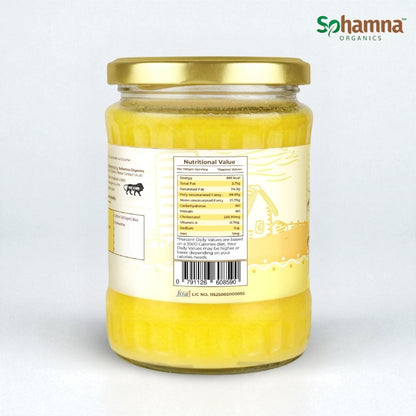 A glass jar of Sohamna Organics butter with a gold lid and cream label, showing the nutritional facts panel on the back, set against a plain light gray background.