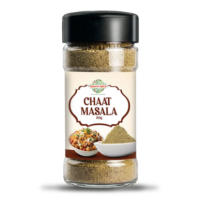 A 100g glass jar of Chaat Masala spice mix by Sohamna Organics, featuring a black lid and a cream-colored label with brown text and food illustrations, set against a plain white background.
