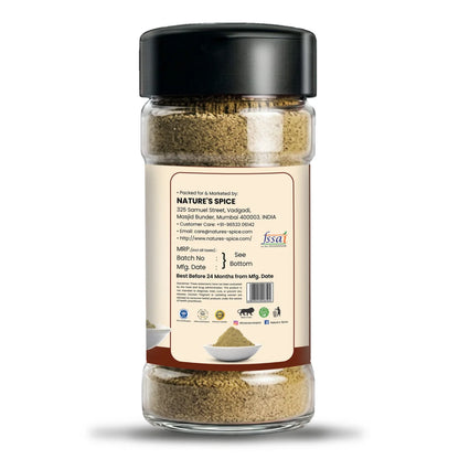 A clear plastic spice jar with a black lid and a beige back label, showing ground spices inside. The label includes the brand name 'Sohamna Organics' and a website URL, set against a plain white background.