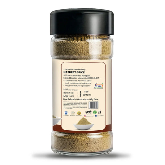 A clear plastic spice jar with a black lid and a beige back label, showing ground spices inside. The label includes the brand name 'Sohamna Organics' and a website URL, set against a plain white background.
