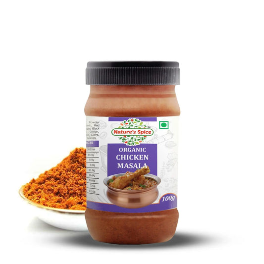 A 100g jar of Sohamna Organics Chicken Masala spice mix, shown with a small white plate of the orange-red ground spice mix in front, on a white background.