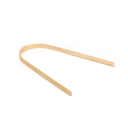 A single curved, thin wooden strip or paddle made of light natural wood, photographed on a seamless white background.